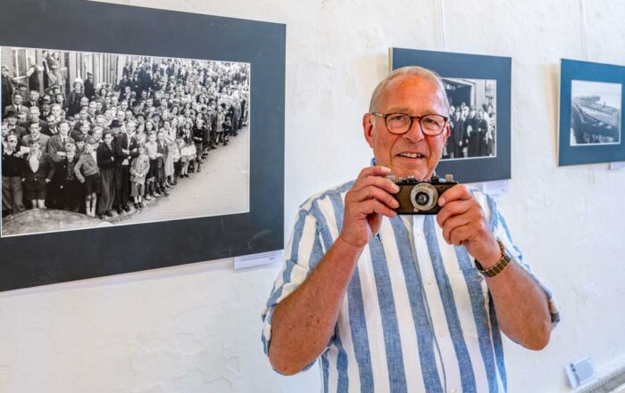 Jan Osinga, zoon van oorlogsfotograaf Jan Dirk Osinga, laat in De Boterhal de Leica camera zien waarmee zijn vader Jan Dirk Osinga tijden de oorlog honderden foto’s maakte (foto Benno Ellerbroek).